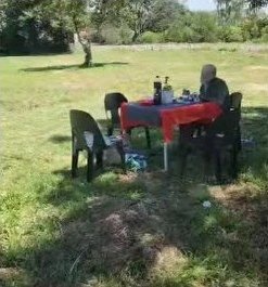 Die tafel en stoele wat op die gras langs die pad uitgesit is