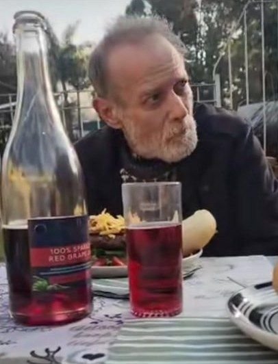'n Man sit by die tafel met 'n maaltyd